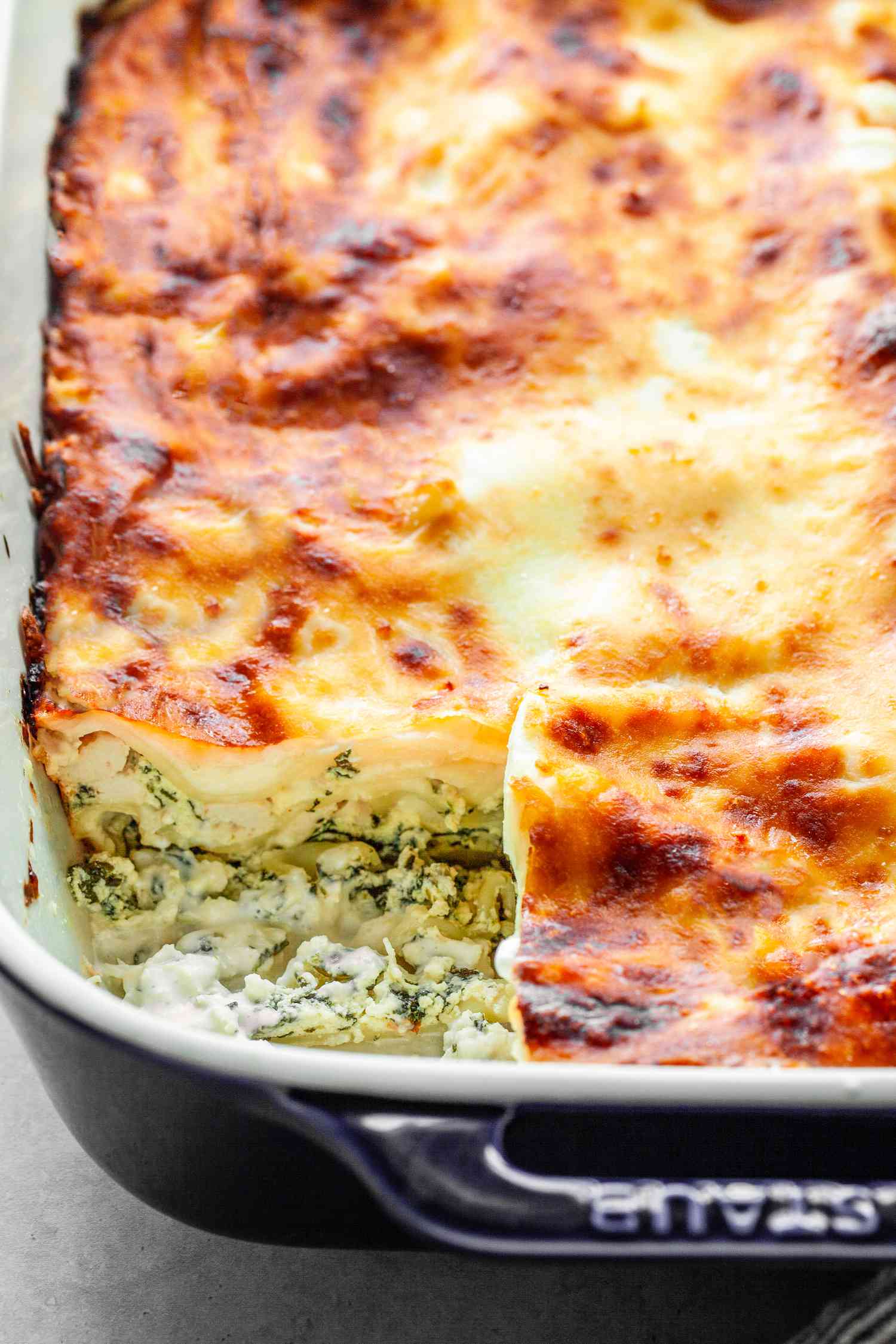 Chicken Lasagna in a Casserole Dish, with a Piece Cut Out