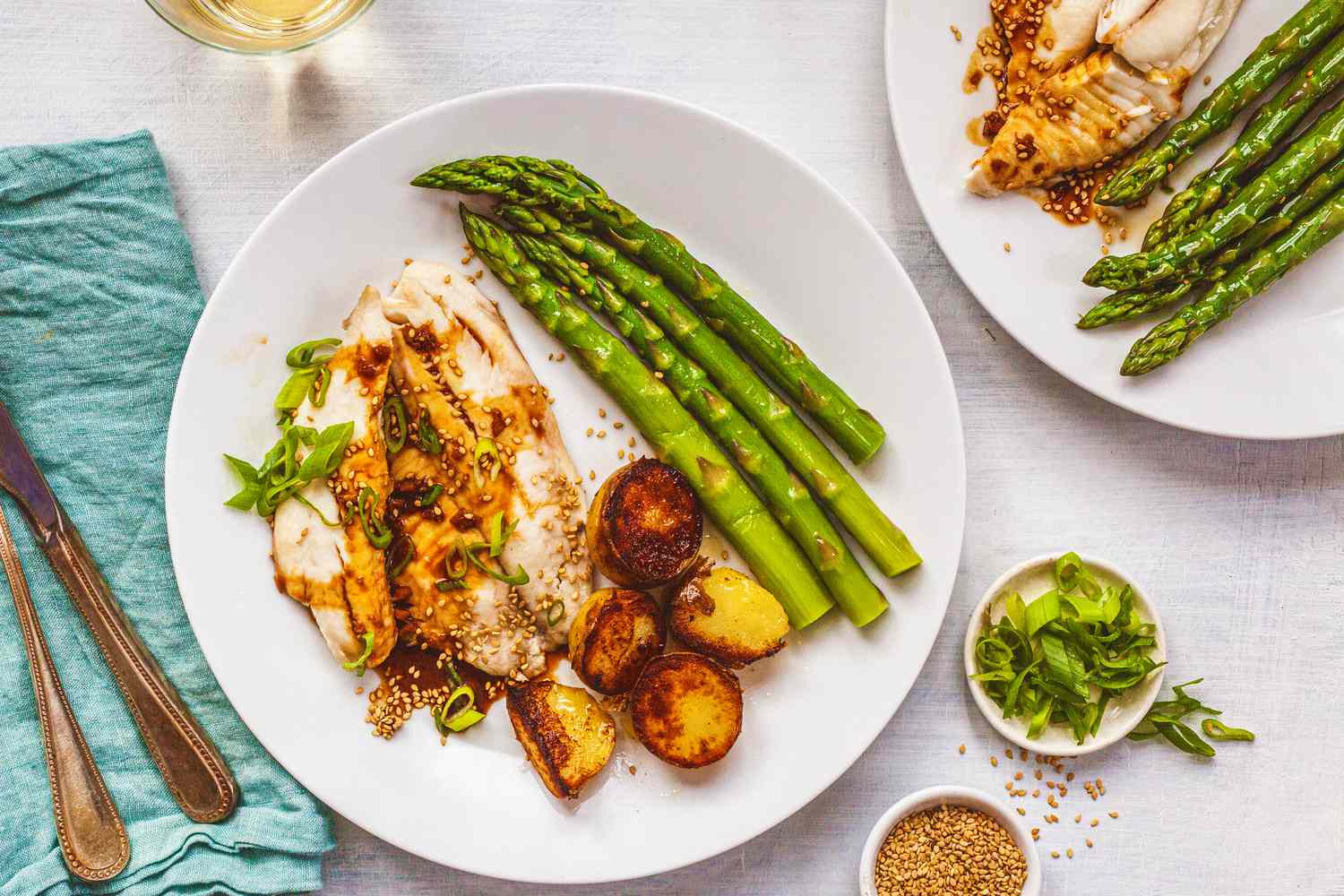 Two plates of ginger-soy tilapia with potatoes and asparagus
