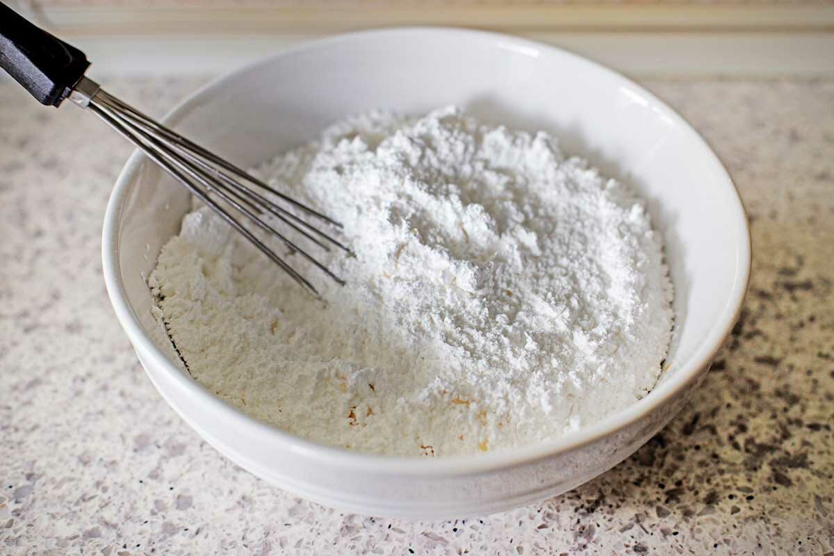 Powdered sugar in a bowl with a whisk to make Hungarian Butter Horns.
