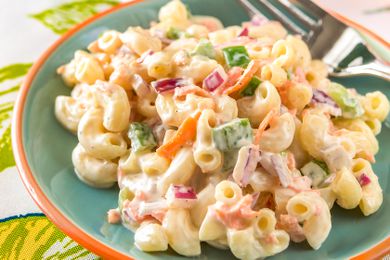 Plate of creamy macaroni salad on a table with a fork