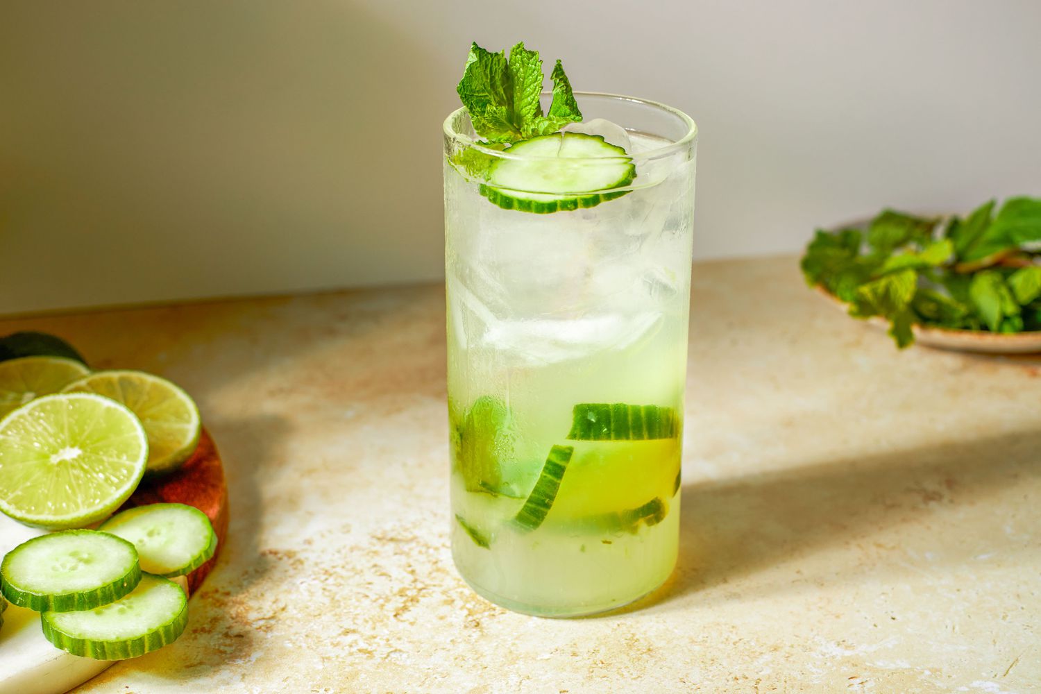 cocktail glass with 3-Ingredient Mocktail Recipe, cucumber slices, lime slices and mint leaves on the side