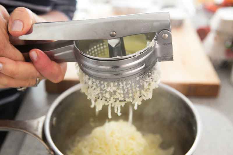 adding garlic to mashed potatoes mixture