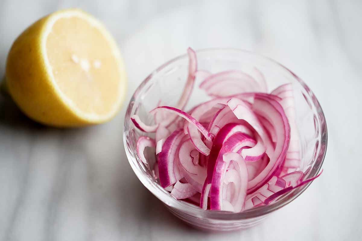 Salad recipe with peaches, goat cheese, and basil soak the onions