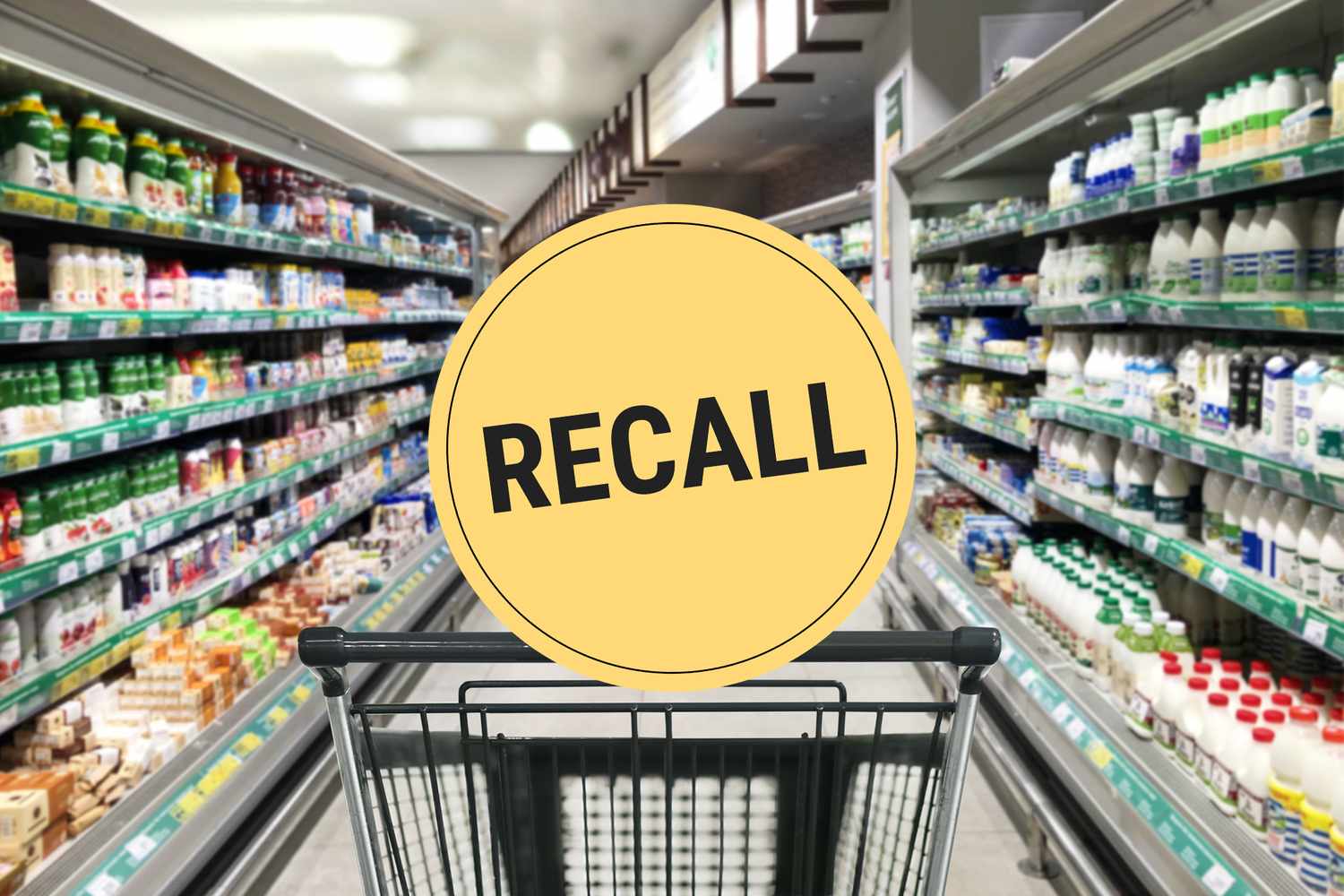 Supermarket aisle with a shopping cart in the foreground and a recall warning sign displayed prominently