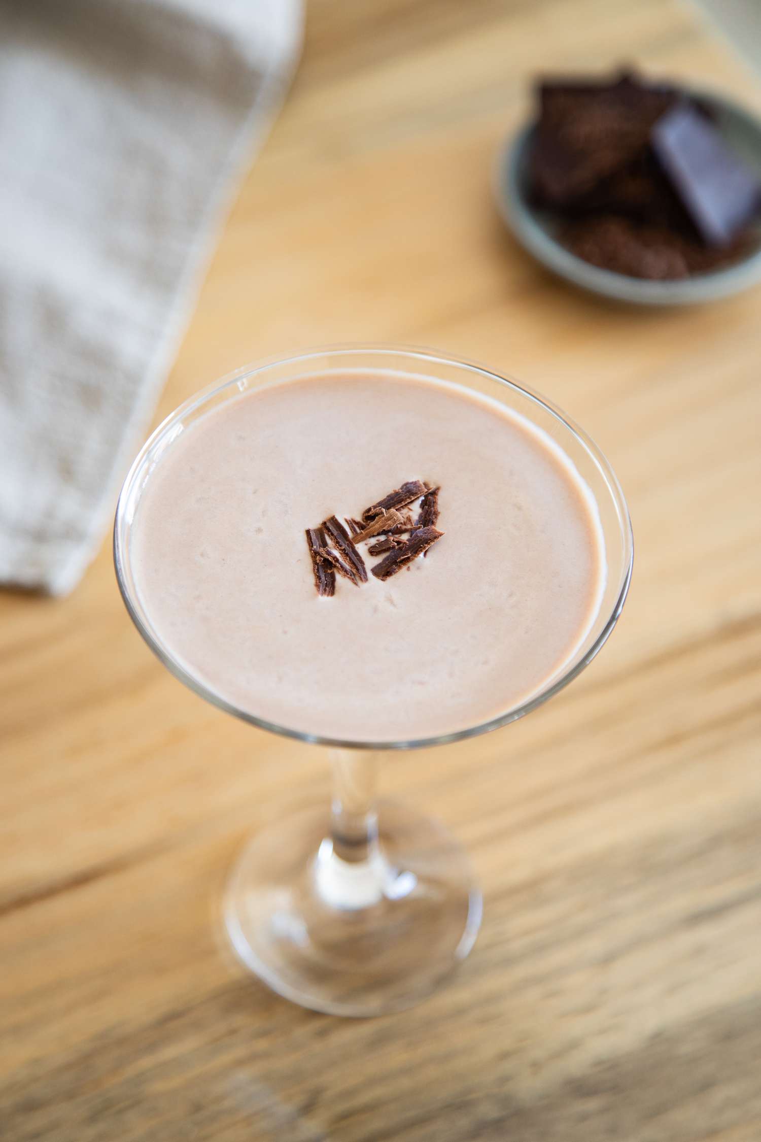 Overhead view of a chocolate martini in a martini glass, garnished with chocolate shavings
