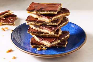 A stack of chocolatecovered cracker candy pieces on a blue plate