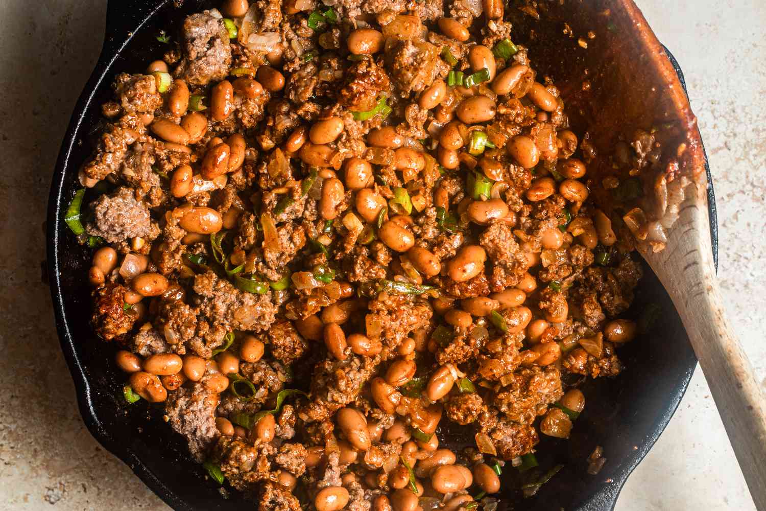 Walking taco casserole filling (ground beef, beans, salsa, etc) cooking together in a cast iron skillet