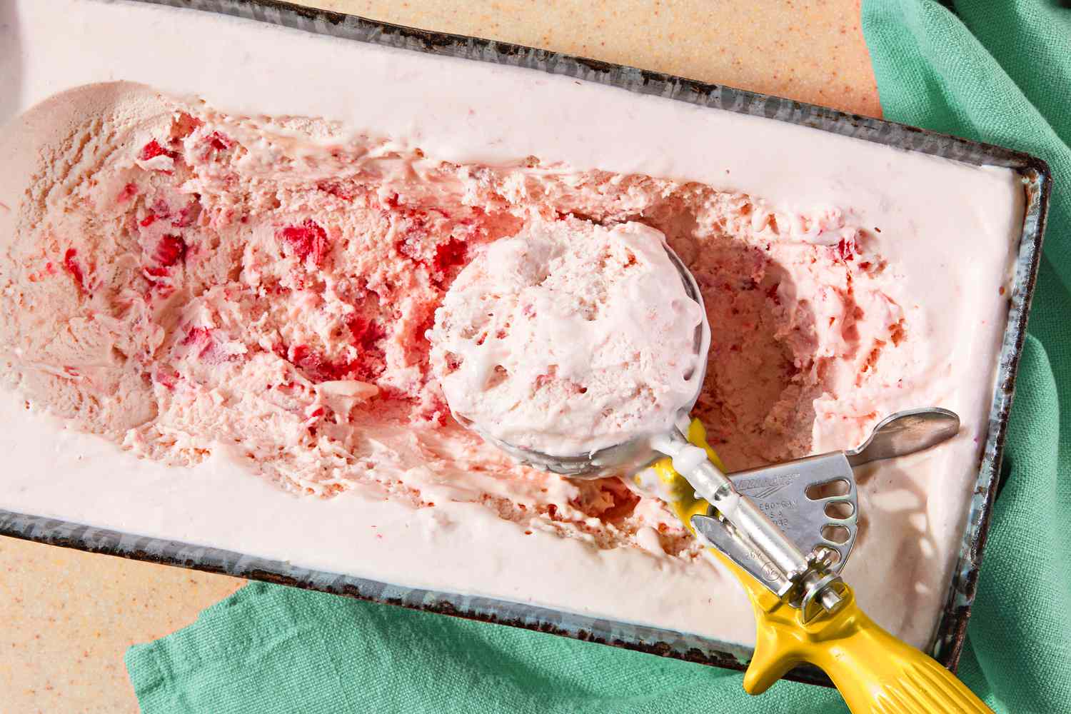 ice cream scoop in a countainer of strawberry marlow 