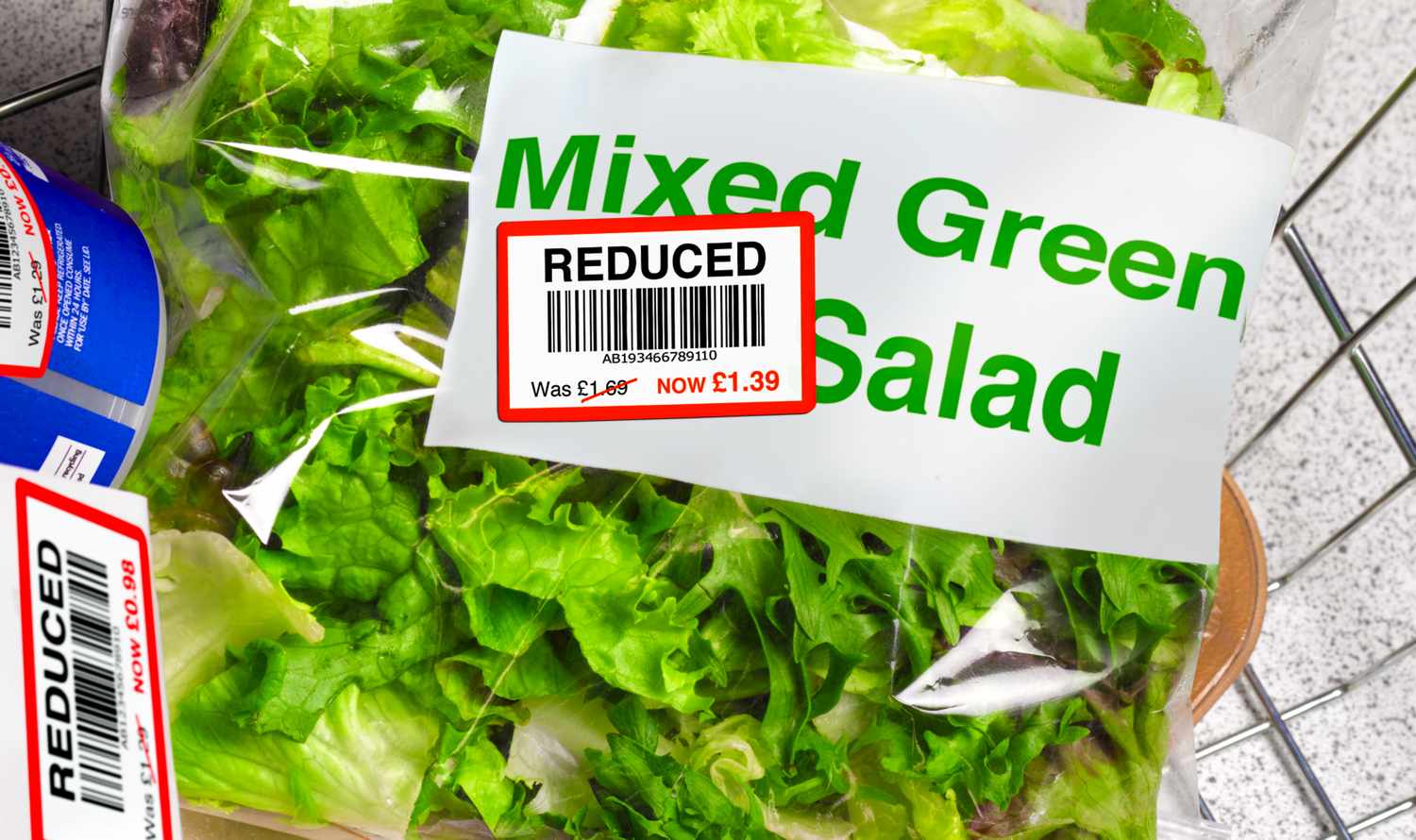Packaged mixed green salad in a grocery cart with a reduced price sticker