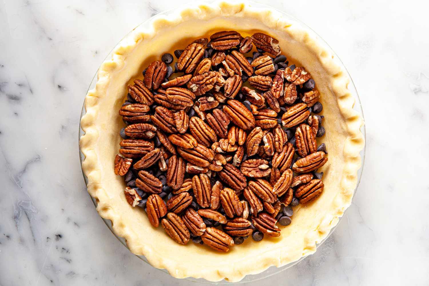 Filling added to a pie crust for chocolate bourbon pecan pie.
