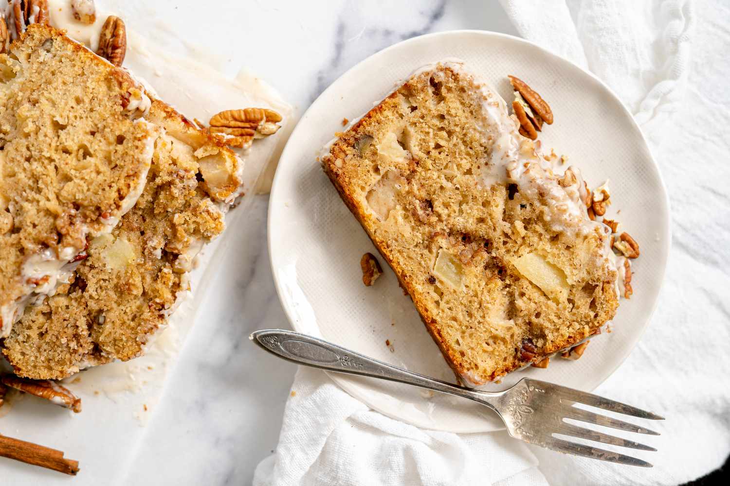 Slice of Apple Fritter Bread on a Plate with More on Parchment Paper Next to It