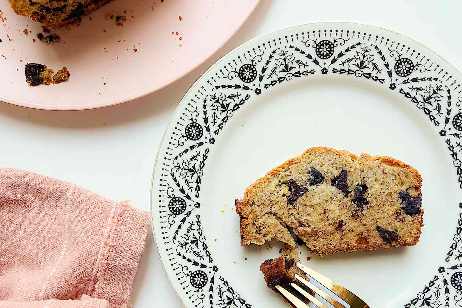 Overhead shot of a plate with a slice of banana chocolate chip bread
