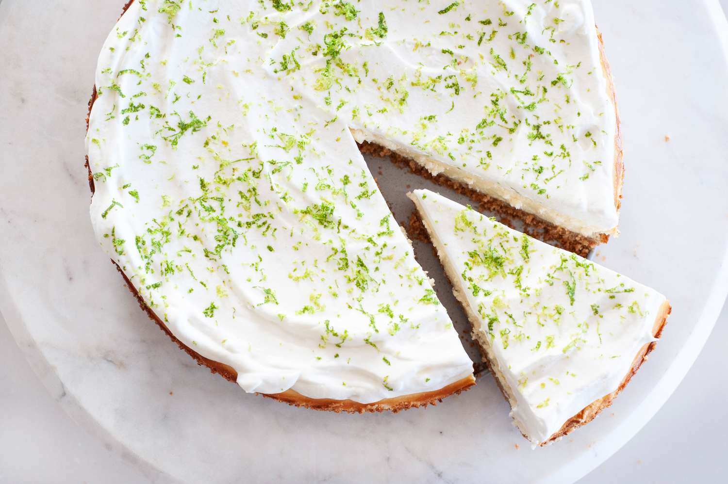 A slice of key lime cheesecake cut out. 