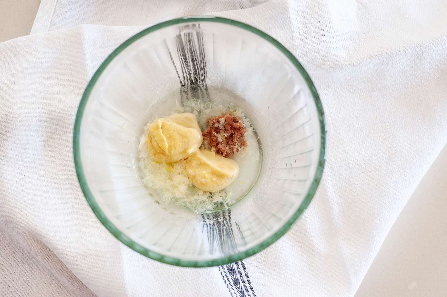 A blender filled with ingredients to make a Basic Dijon Anchovy Vinaigrette.