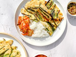 Pajeon, Kimchi, and Rice on a Plate Next to a Small Bowl of Sauce