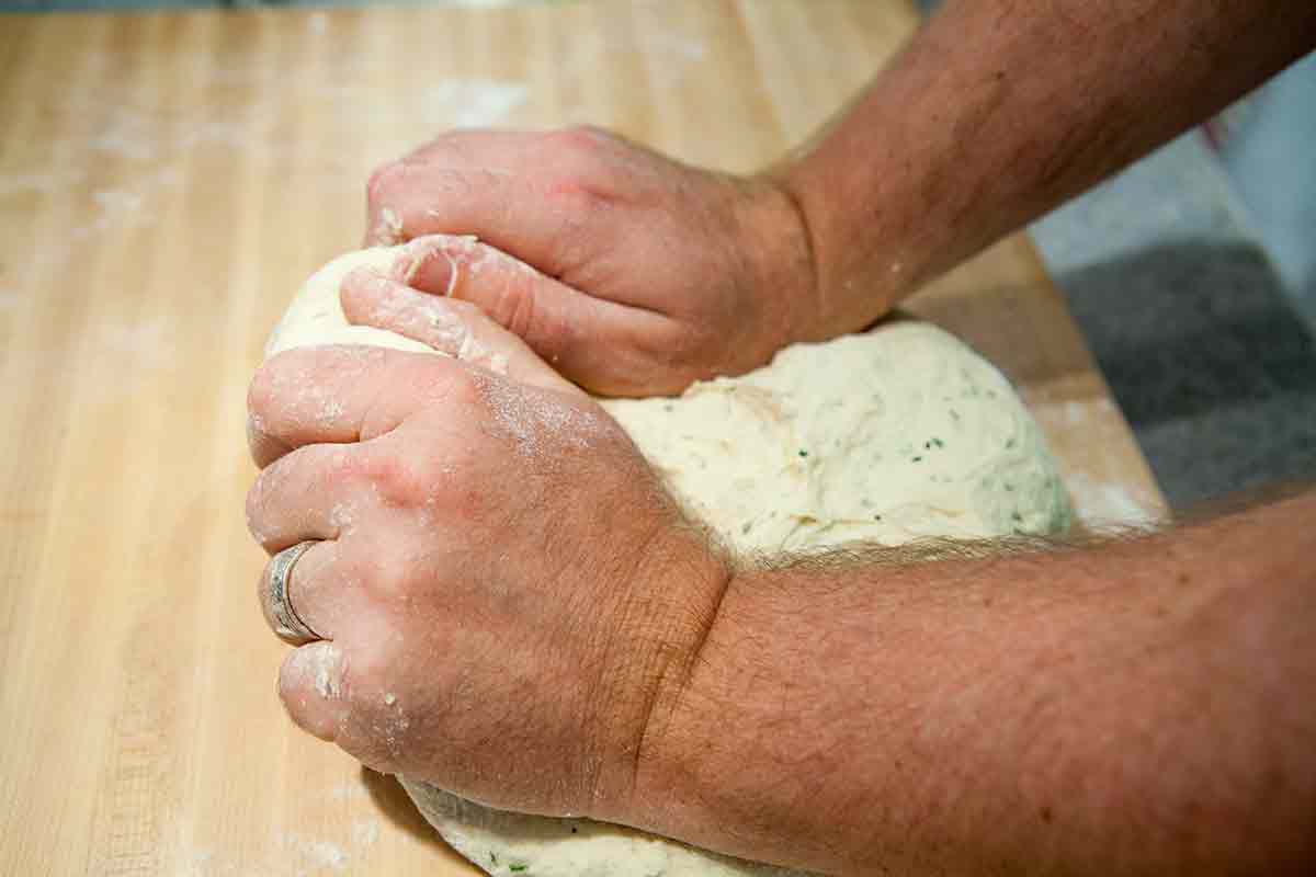Knead the dough for focaccia bread until smooth and slightly tacky