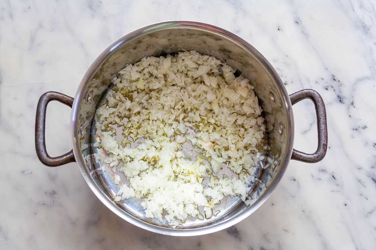 Onions in the bottom of a soup pot for lentil soup.