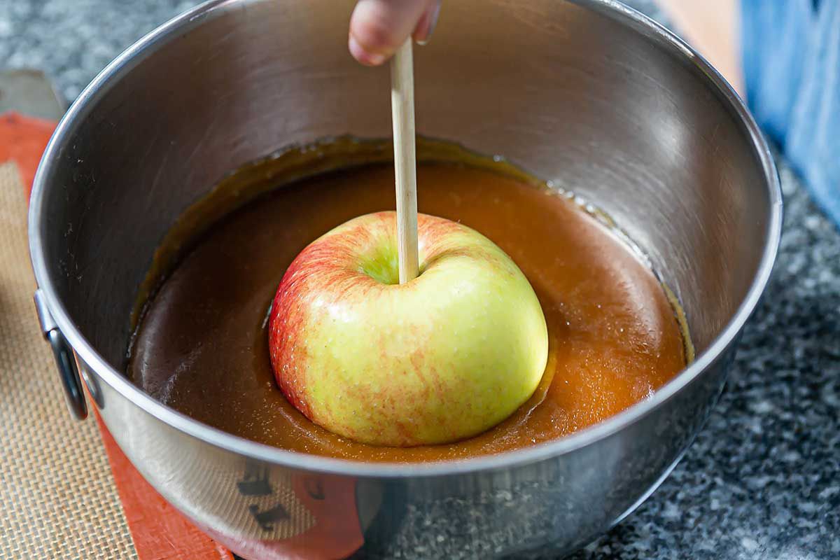 Caramel Apples dip the apples into the caramel
