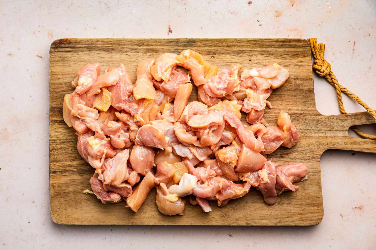 Chicken Cut into Bite Size Pieces on a Cutting Board for Chicken and Broccoli Pasta Recipe