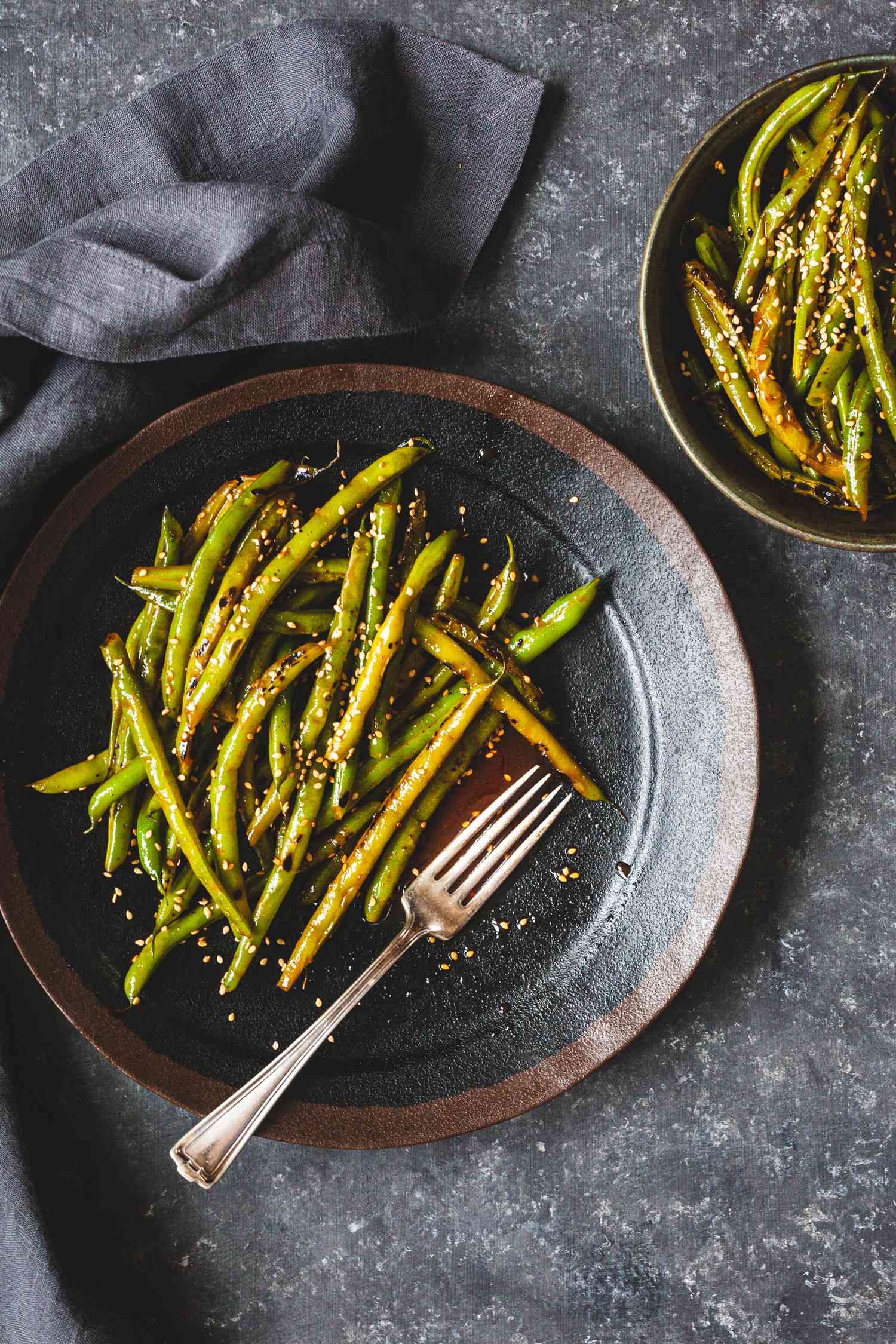 Spicy Blistered Green Beans with Gochujang served on two plates.