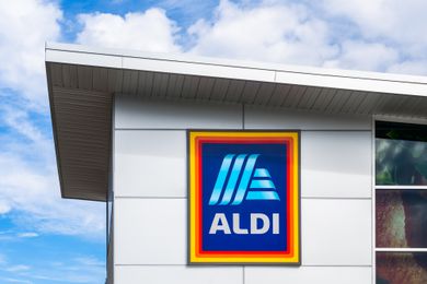 Aldi sign on an Aldi store with clouds and blue sky overhead