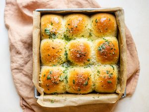 Overhead view of garlic Parmesan pull apart bread in a pan with a linen underneath.