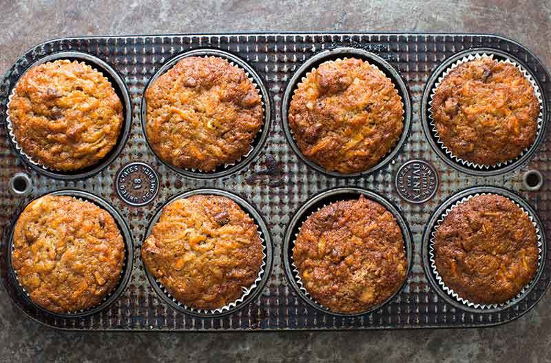 Carrot and Apple Cupcakes Eight baked apple cupcakes with carrots in muffin tin