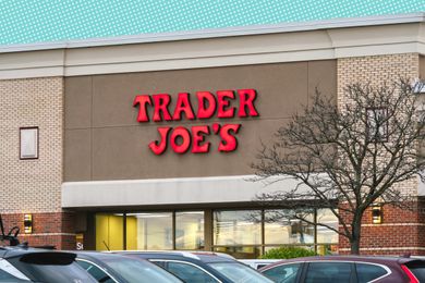 Exterior of a Trader Joes store with parked cars in the foreground