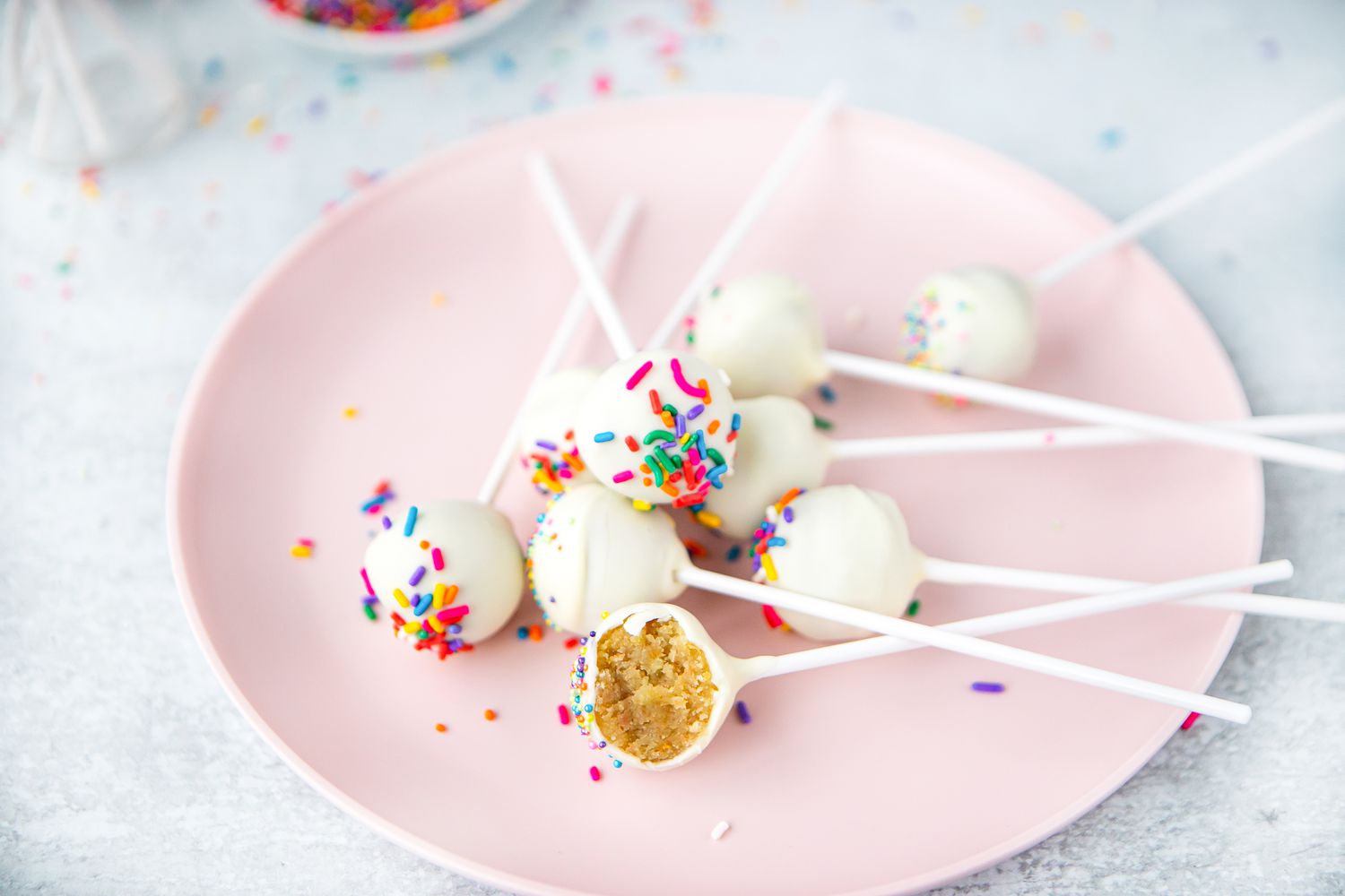 Cake Pops with Sprinkles on Plate with One Partially Eaten