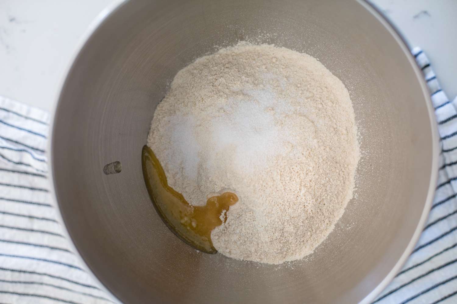 Adding ingredients to a bowl to make a roti recipe.