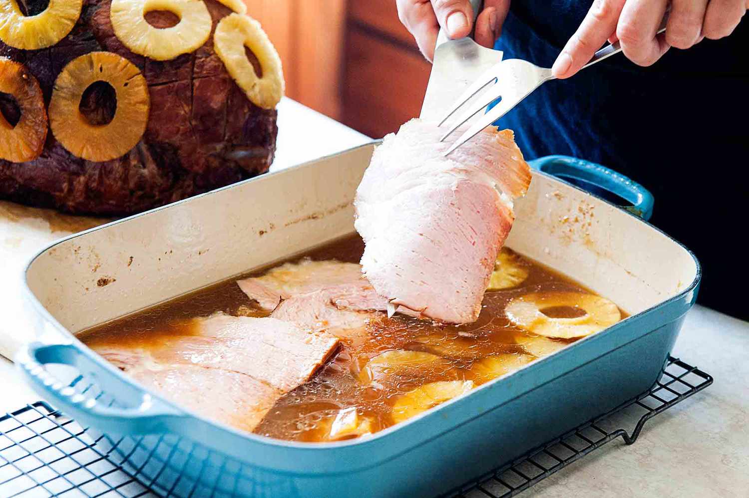 Glazed Ham with Brown Sugar - ham slices being placed in cooking juices