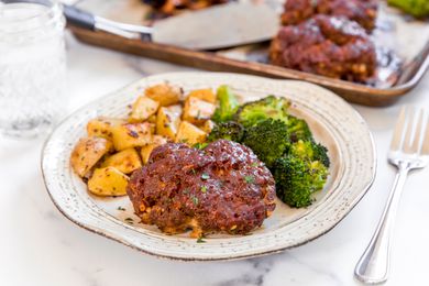 Sheet pan meatloaf dinner on a plate with broccoli and potatoes.