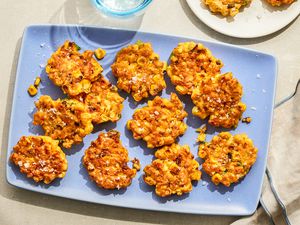 Corn fritters arranged on a blue plate