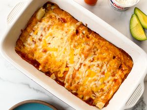 Taquito enchilada casserole in a white baking dish