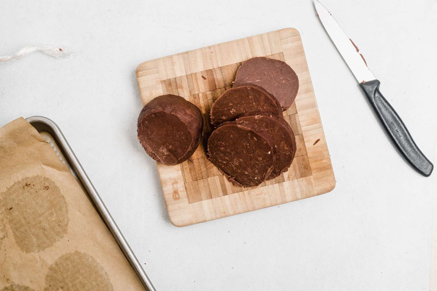 Slicing easy shortbread with chocolate and crushed peppermint into rounds.
