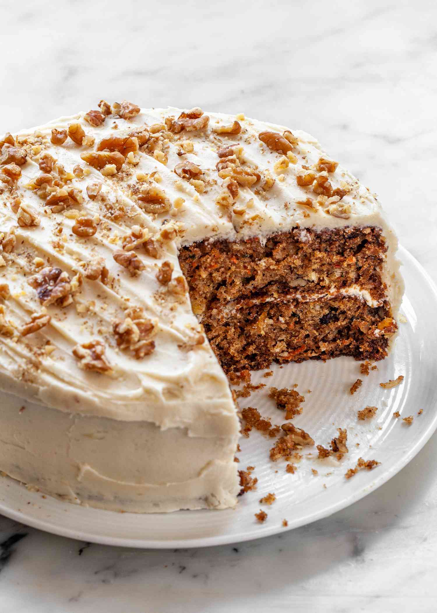 The best carrot cake recipe with a slice removed from the layered cake.