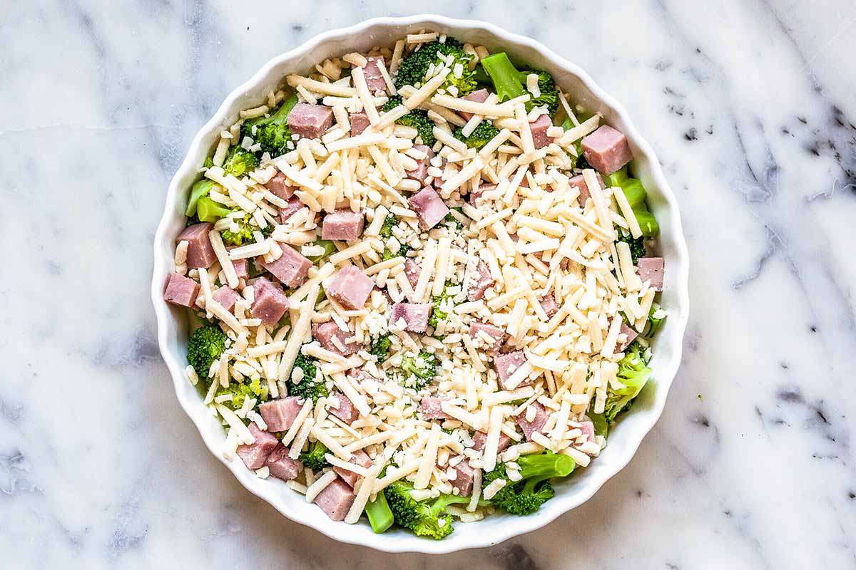 Crustless Quiche with Ham - vegetables, cheese, cubed ham in white dish