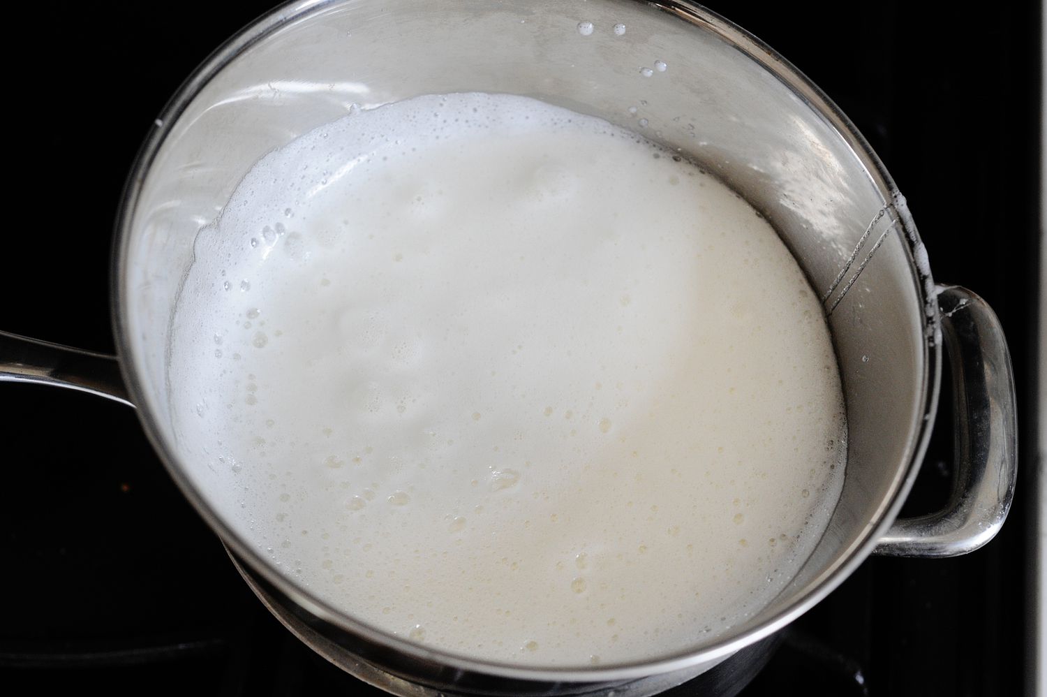 Frothy egg whites in a bowl to make No Fail Seven-Minute Frosting.