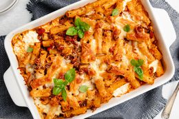 Pasta bake in a casserole dish, topped with basil