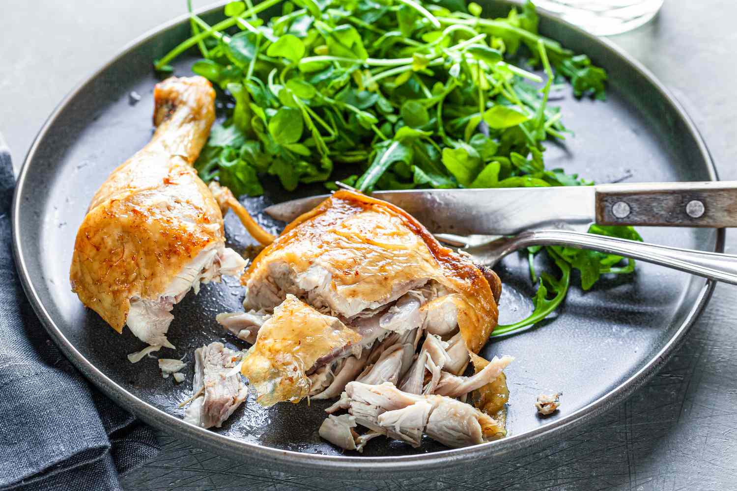 Chicken confit cut into with a side of greens.