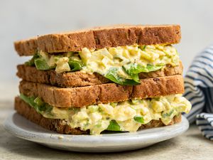 Homemade egg salad sandwich on a plate with a leaf of lettuce