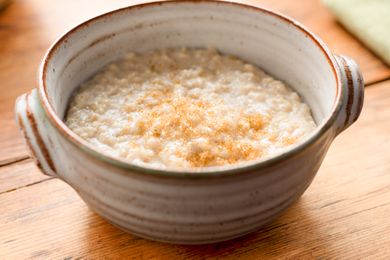 A bowl of oatmeal topped with a sprinkle of brown sugar