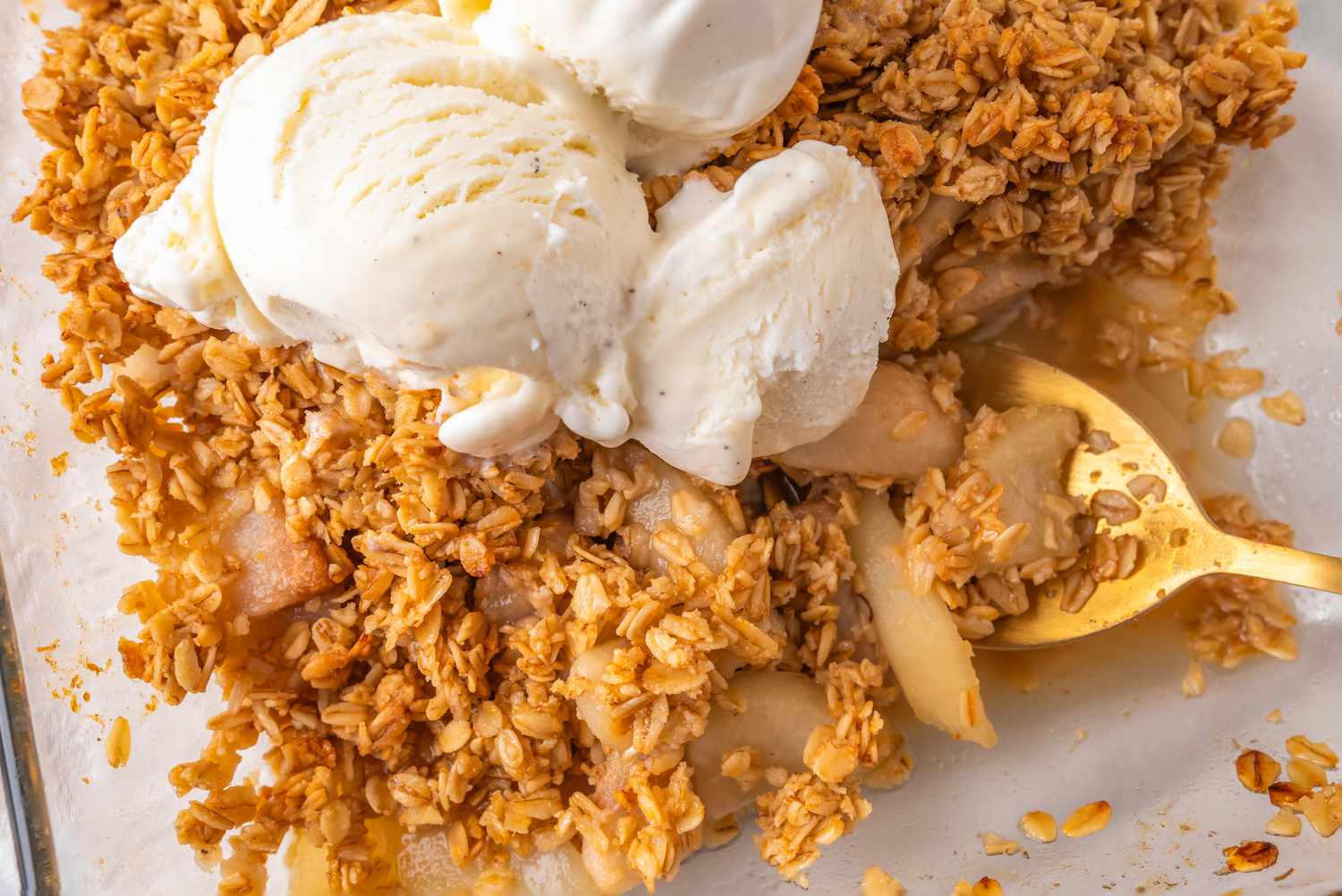 Overhead view of vanilla pear crisp recipe topped with vanilla ice cream