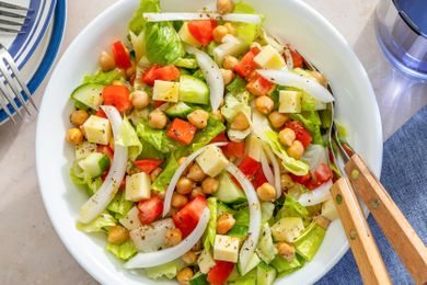 Bowl of Sicilian chopped salad with utensils on the side