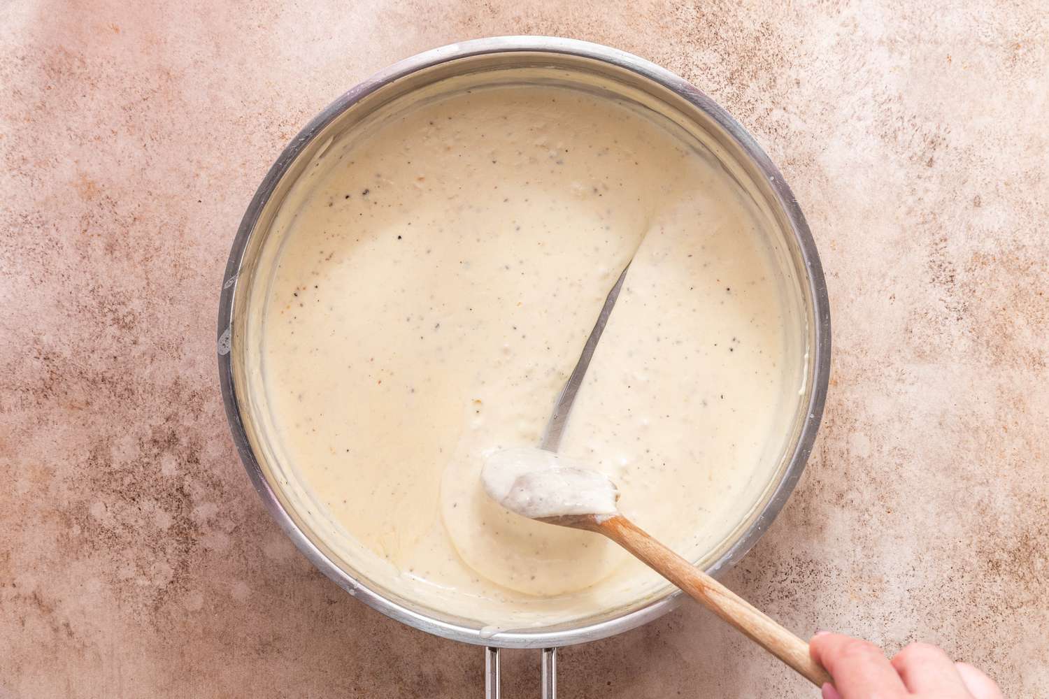 Creamy Cavatappi Sauce Reduced Thickened. Wooden Spoon Stirring the Sauce and Leaving a Clear Streak to Showcase Desired Consistency