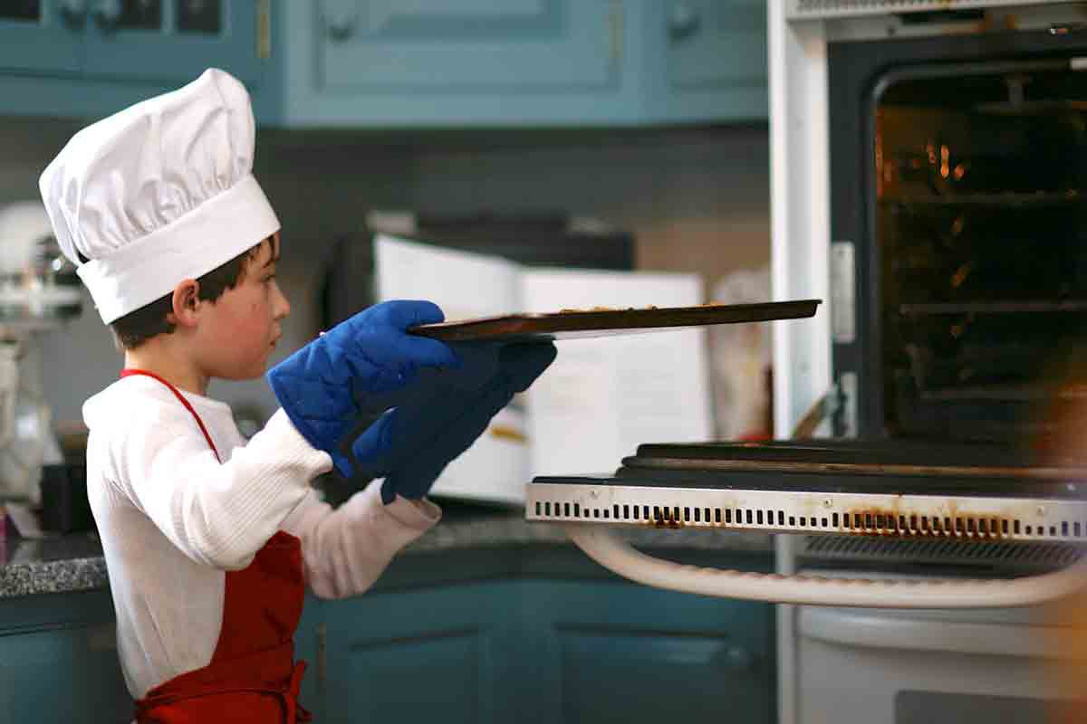 child putting crunchy french toast in oven
