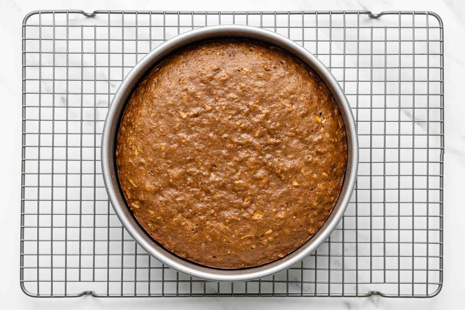 Cake Pan With Baked Coffee Coconut Banana Bread Cake Resting on a Wire Rack 