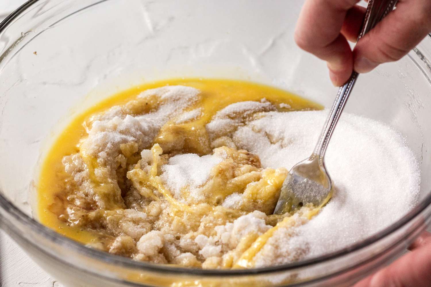 Sugar mixed with butter and bananas to make banana bread.