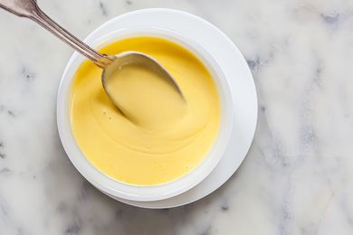 Classic Hollandaise Sauce in a small bowl with a spoon.