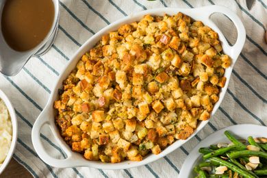 An oval white baking dish with stuffing